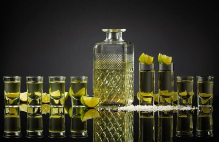 Photo for Tequila shots with lime slices and salt on a black reflective background. Copy space. - Royalty Free Image