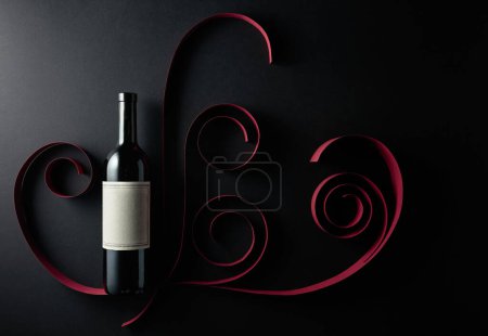 Photo for Bottle of red wine with old empty label on a black background. Top view. - Royalty Free Image