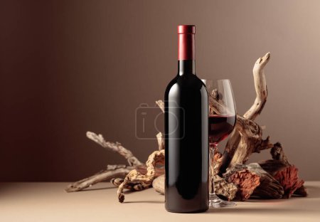 Photo for Bottle and glass of red wine with a composition of old wood. Minimalistic composition on a beige background for product branding, identity, and packaging. Copy space. - Royalty Free Image