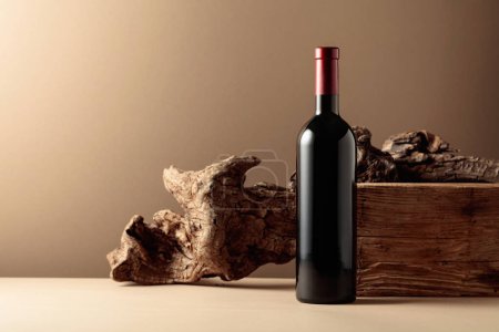 Photo for Bottle of red wine with old wood on a beige background. Copy space. - Royalty Free Image