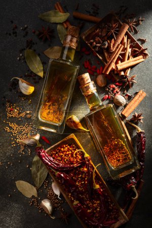 Foto de Las botellas del aceite de oliva y las especias distintas a la mesa de la cocina. Vista superior. - Imagen libre de derechos