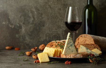 Photo for Cheese, bread, red wine, and walnuts on a kitchen table. Traditional Mediterranean snacks. - Royalty Free Image
