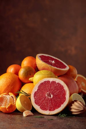 Photo for Citrus fruits on a old brown table. Presented are oranges, grapefruits, lemons, and tangerines. Copy space. - Royalty Free Image