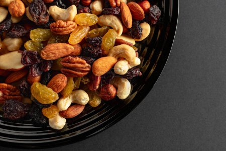 Photo for Mix of dried nuts and raisins on a black background. Top view. Copy space. - Royalty Free Image