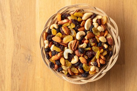 Photo for Mix of dried nuts and raisins on a wooden background. Top view. Copy space. - Royalty Free Image