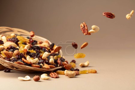 Téléchargez les photos : Voler des fruits secs et des noix. Le mélange de noix séchées et de raisins secs sur fond beige. Espace de copie. - en image libre de droit