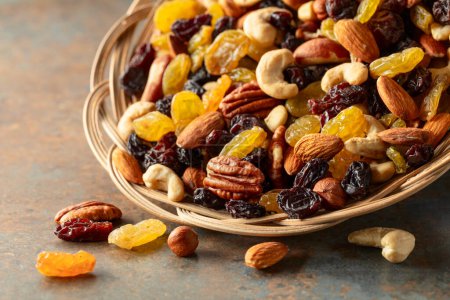 Photo for Mix of dried nuts and raisins on a rustic background. Copy space. Selective focus. - Royalty Free Image
