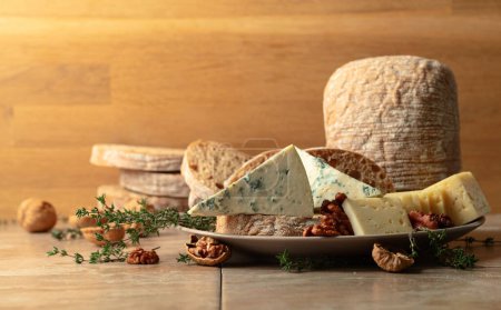 Photo for Cheese, bread, walnuts, and thyme on a kitchen table. Copy space. - Royalty Free Image
