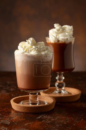 Photo for Creamy milk chocolate drinks. Homemade latte with whipped cream on a old brown table. Copy space. - Royalty Free Image
