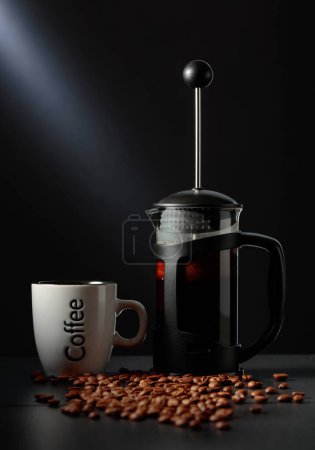 Téléchargez les photos : Presse française café et une tasse sur une table noire avec des grains de café. - en image libre de droit