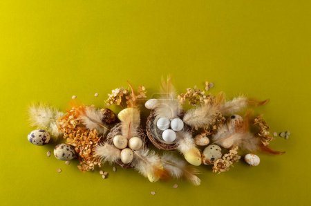 Foto de Composición de Pascua con huevos de codorniz, plumas y flores secas. Vista superior. Fondo verde con espacio de copia. - Imagen libre de derechos