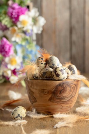Foto de Composición de Pascua con huevos de codorniz, plumas y flores de primavera sobre una vieja mesa de madera. Copiar espacio. - Imagen libre de derechos