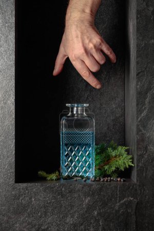 Foto de Hand reach for a decanter of gin. A concept image on the theme of expensive drinks. - Imagen libre de derechos