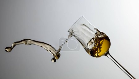 Photo for The drink spills out of the glass. Concept of the theme of premium alcohol. Copy space. - Royalty Free Image