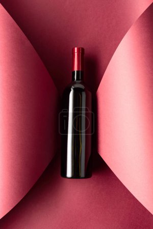 Téléchargez les photos : Bouteille de vin rouge sur fond rouge. Vue du dessus. - en image libre de droit
