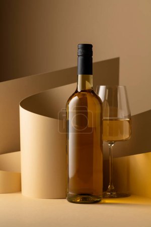 Foto de Bottle and glass of white wine on a beige background. Copy space. - Imagen libre de derechos