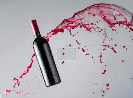 Téléchargez les photos : Bouteille de vin rouge et éclaboussures. Espace de copie. - en image libre de droit