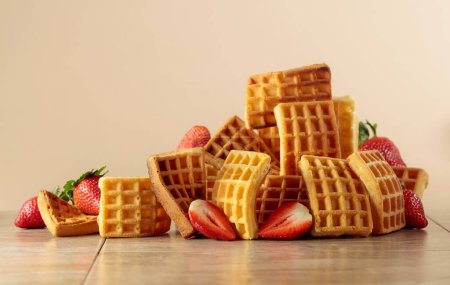 Photo for Belgian waffles with strawberries on a beige ceramic table. - Royalty Free Image