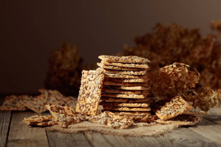 Photo for Crispy crackers with sunflower and flax seeds on an old wooden table. Simple healthy food. Copy space. - Royalty Free Image