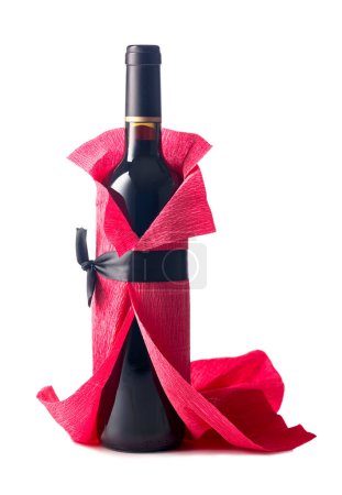 Téléchargez les photos : Bottle of red wine wrapped in crepe paper isolated on a white background. The bottle looks like a woman in a red evening dress. - en image libre de droit