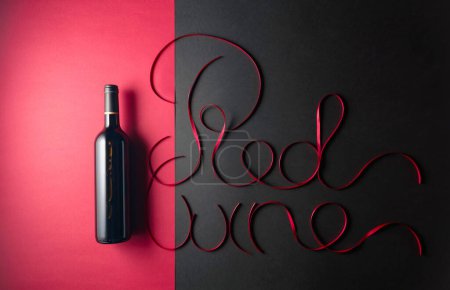 Téléchargez les photos : Bouteille de vin rouge avec rubans de satin rouge. Vue du dessus. - en image libre de droit