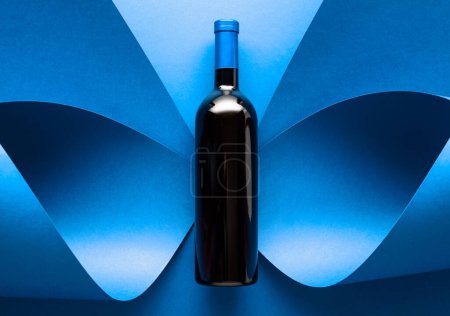 Foto de Botella de vino tinto sobre fondo azul. Vista superior. - Imagen libre de derechos