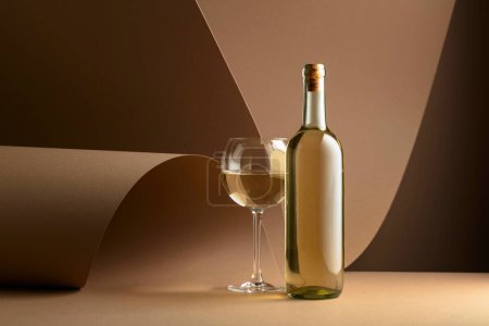 Téléchargez les photos : Bottle and glass of white wine on a beige background. Copy space. - en image libre de droit