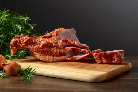 Téléchargez les photos : Porc fumé avec romarin et oignon sur une planche à découper. - en image libre de droit