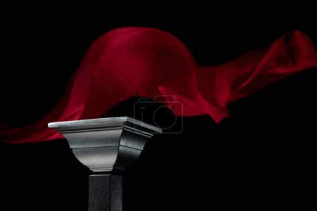 Foto de Lujoso podio negro sobre un fondo de ondulante cortina de atlas rojo. Plataforma perfecta para mostrar sus productos sobre un fondo oscuro. - Imagen libre de derechos