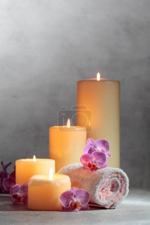 Foto de Toallas, flores de orquídea y velas encendidas. Concepto de spa con espacio para copiar. - Imagen libre de derechos