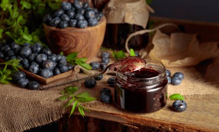 Photo for Blueberry jam with fresh berries on an old wooden table. - Royalty Free Image