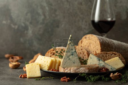 Foto de Queso, pan, vino tinto y nueces en una mesa de piedra. Snacks tradicionales mediterráneos. - Imagen libre de derechos