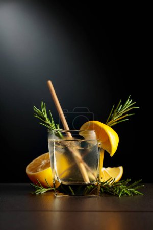 Foto de El vaso congelado con un cóctel de gin tonic sobre fondo negro. - Imagen libre de derechos