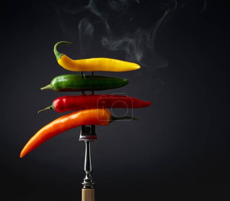 Photo for Hot chili peppers with smoke on a black background. Concept of spicy food. - Royalty Free Image