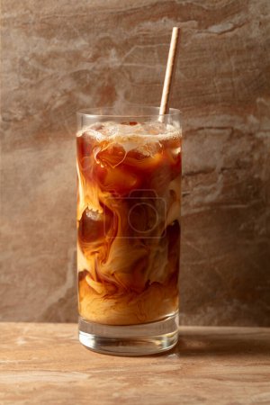 Photo for Iced coffee with cream, refreshing and sweet coffee drink on a beige ceramic table. - Royalty Free Image