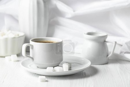 Foto de Una taza de café negro y azúcar en una mesa de madera blanca. Copiar espacio. - Imagen libre de derechos