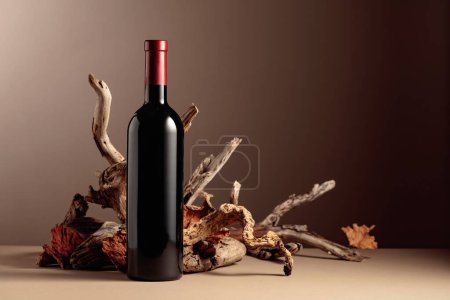 Photo for Bottle of red wine with a composition of old wood. Minimalistic composition on a beige background for product branding, identity, and packaging. Copy space. - Royalty Free Image