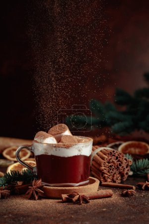 Téléchargez les photos : Chocolat chaud de Noël avec guimauves saupoudrées de cacao en poudre. Photographie de boisson d'hiver sur fond brun foncé. - en image libre de droit
