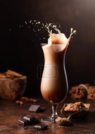 Téléchargez les photos : Pièce de chocolat noir tombent dans un verre de boisson de cacao créant une belle éclaboussure. - en image libre de droit