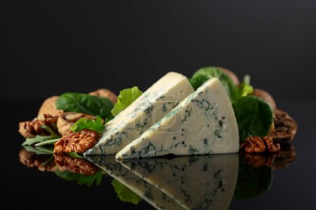 Photo for Blue cheese with walnuts and fresh greens on a black background. - Royalty Free Image