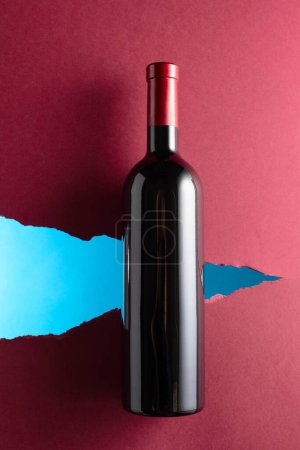 Foto de Botella de vino tinto sobre fondo rojo oscuro. Vista superior. - Imagen libre de derechos