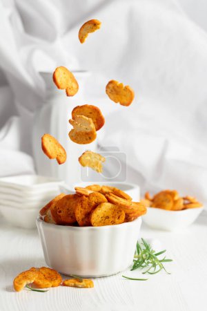 Photo for Spicy bruschetta crackers with rosemary on a white kitchen table. Traditional Italian snack. - Royalty Free Image
