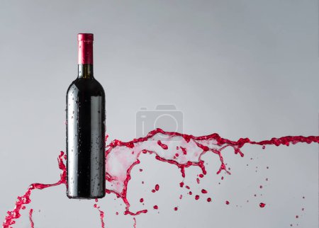 Téléchargez les photos : Bouteille de vin rouge et éclaboussures. Espace de copie. - en image libre de droit