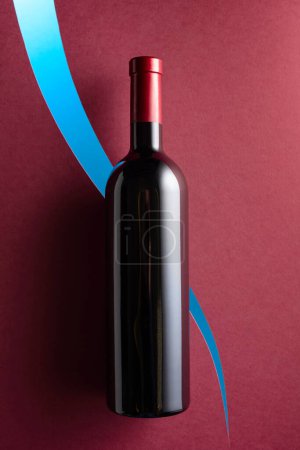 Téléchargez les photos : Bouteille de vin rouge sur fond rouge foncé. Vue du dessus. - en image libre de droit