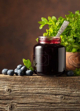 Photo for Jar of blueberry jam with fresh berries and leaves on an old wooden table. - Royalty Free Image