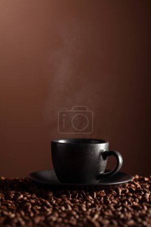 Téléchargez les photos : Tasse noire de café sur la table avec des haricots éparpillés. Espace de copie. - en image libre de droit
