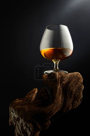 Foto de Francotirador de brandy en un viejo enganche de madera. Fondo negro con espacio de copia. Enfoque selectivo. - Imagen libre de derechos