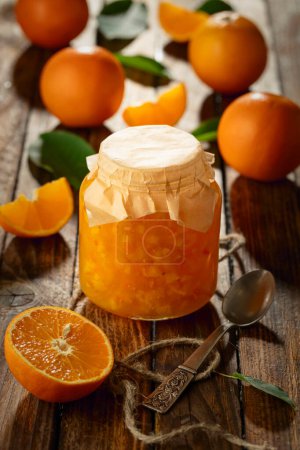 Photo for Orange jam in glass jar and fresh fruits on an old wooden table. - Royalty Free Image