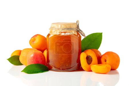 Téléchargez les photos : Confiture d'abricots dans un bocal en verre et fruits frais isolés sur fond blanc. - en image libre de droit