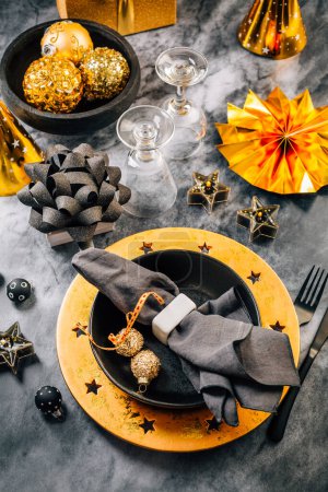 Photo for Glamorous black and gold place setting with modern plates for New Years Eve and Christmas - Royalty Free Image